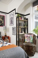 Bedroom with a black faux panelling effect (using black washi tape), framed artwork and an animal print armchair.