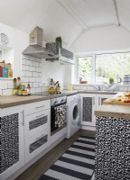 Kitchen with animal print cabinets and white metro tiles.