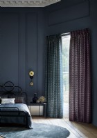 Dark blue bedroom with tall windows and curtains