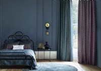 Dark blue bedroom with tall window and curtains