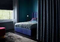 Rich blue bedroom with curtain divider