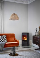 Wood burning stove in living room with orange sofa