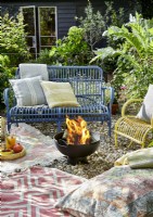 Fire pit in garden with outdoor sofa and chairs