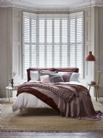 Relaxed modern bedroom with white shutters 