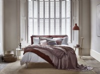 Relaxed modern bedroom with white shutters