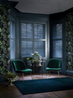 Living room with green chairs and blue shutters