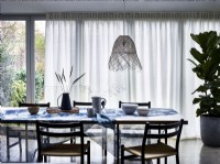 Dining table with white voile diffuser curtains
