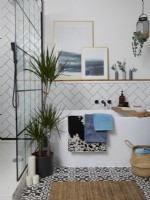 Bathroom with a freestanding bath, white metro tiles in a herringbone pattern and a crittall walk in shower cubicle.