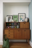 Mid-century cabinet with storage and artwork. Part of an open plan kitchen-diner living space.