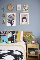 Bedroom detail showing a gallery wall and colourful bedding.