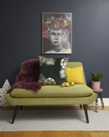 Living room with green sofa, artwork and gold Christmas baubles.