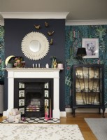 Living room with printed wallpaper, fireplace and an upcycled glass cabinet. Christmas decoration details.
