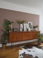 Open plan living area showing pink colour blocking and a mid-century sideboard.