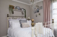 Bedroom with metal bed and white bedding.