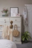 Bedroom detail showing metal bed and a white shabby chic chest of drawers.