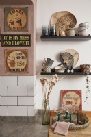 Kitchen detail showing vintage signs and open shelving for teacups.
