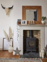 Living room detail with fireplace, pampas grass and a skull wall decoration.