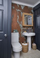 Bathroom with copper effect wall and navy painted doors.