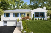 White single story mid century modern brick family home with blue shutters and green lawn