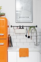 Sink detail white kitchen with orange accents

