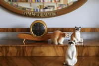 Clock standing on the sideboard in the company of glass figurines