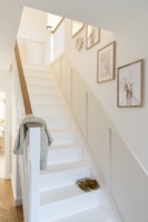 White painted wooden staircase with dado panelling