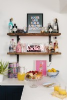 Detail of a bar on a kitchen shelving unit with lighted neon sign