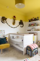 Child's bedroom with cot and yellow scalloped ceiling