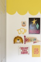 Detail of gallery wall in a child's bedroom with yellow scalloped painted ceiling