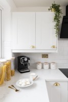 Detail of a corner in a styled white modern kitchen with worktop and cupboard