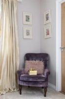 Purple velvet chair in the corner of a bedroom



