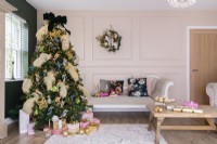 Christmas tree decorated with feathers and birds in a pink panelled living room