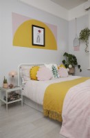 Bedroom with colour block shapes painted on the wall.