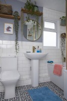 Bathroom with white tiles, grey walls, patterned flooring and open shelving.