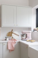Detail of the corner of a white kitchen with pale pink food mixer