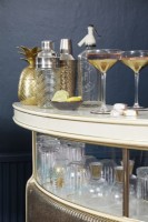 Living room showing detail of the gold drinks bar, with cocktail glasses and a shaker.