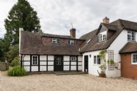 Black and white timber framed country cottage with pebbled drive