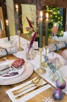 Detail of place setting at a dining table with Christmas tree in the background