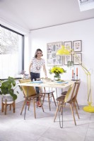 Open plan dining area with Ercol vintage chairs and a yellow floor lamp.