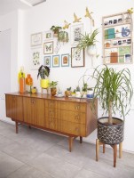 Open plan living area with mid century sideboard, retro ornaments and artwork on the walls.