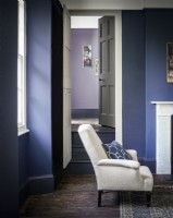 Purple/blue painted living room with chair in from of doorway