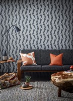 Grey sofa with vertical patterned wallpaper and cow hide coffee table