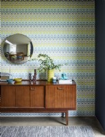 Yellow patterned wallpaper with mid century sideboard