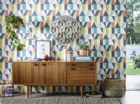Modern retro sideboard in from of patterned wallpaper