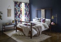 Bedroom with blue painted wall and patterned curtains