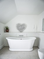 White roll top bath in classic white bathroom