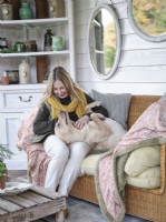 Portrait of homeowner Tracey Gill on the porch with pet dog 