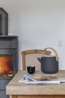 A kettle with tea and a fireplace in the background