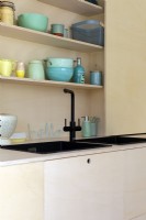 Sink detail in modern ply kitchen with colourful accessories
