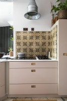 Detail of built in hob, cement tiles and industrial cooker hood